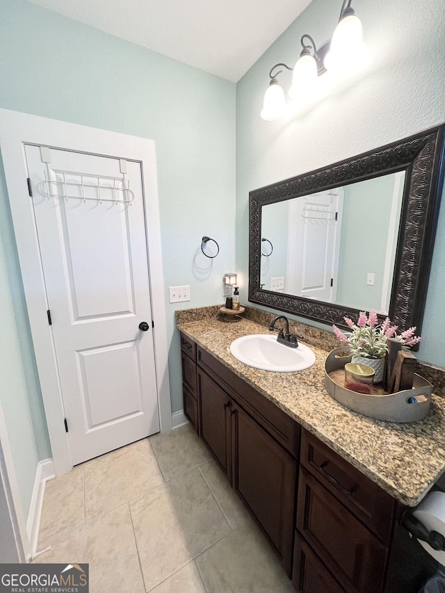 bathroom with tile patterned flooring, vanity, and baseboards