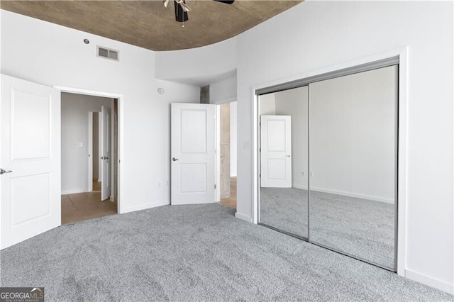 unfurnished bedroom featuring carpet flooring, a closet, and ceiling fan