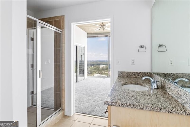 bathroom with ceiling fan, tile patterned flooring, vanity, and a shower with shower door