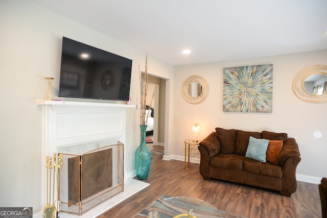 living room with dark wood-type flooring and a high end fireplace