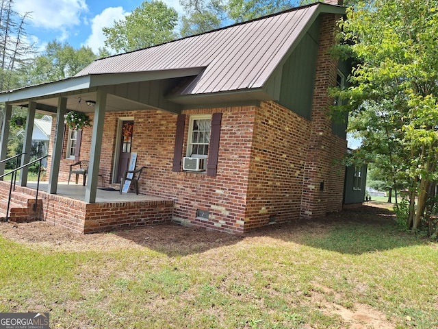 view of front of home with cooling unit, a front lawn, and covered porch