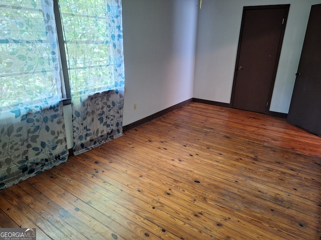 unfurnished room with plenty of natural light and dark hardwood / wood-style flooring