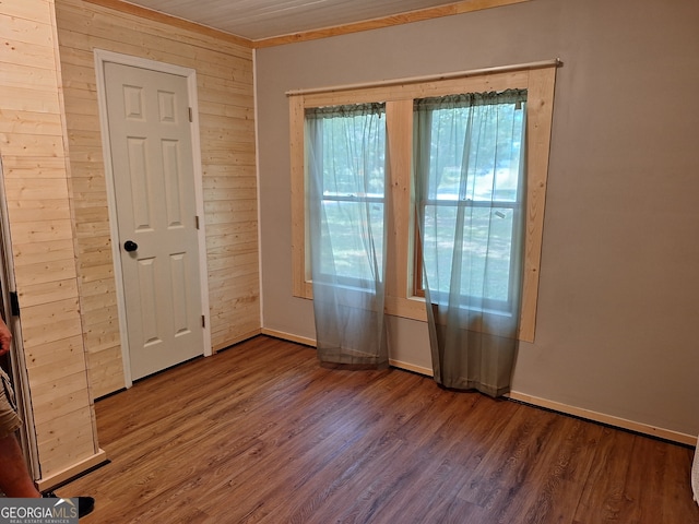 unfurnished room featuring wood walls and dark hardwood / wood-style floors