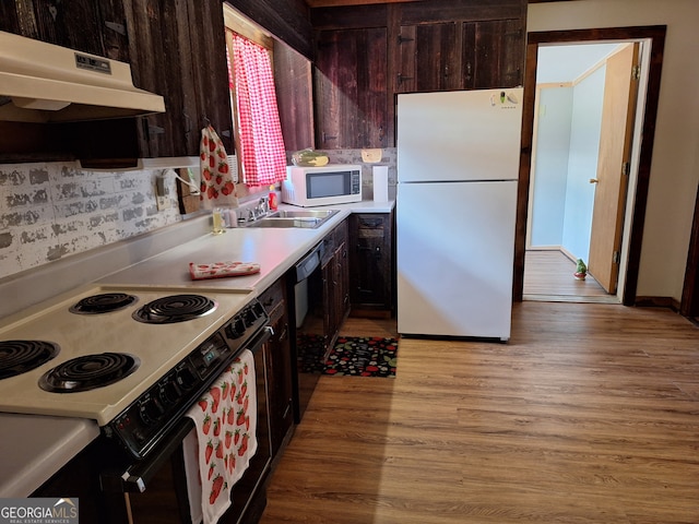 kitchen featuring dark brown cabinetry, sink, white appliances, tasteful backsplash, and light hardwood / wood-style floors