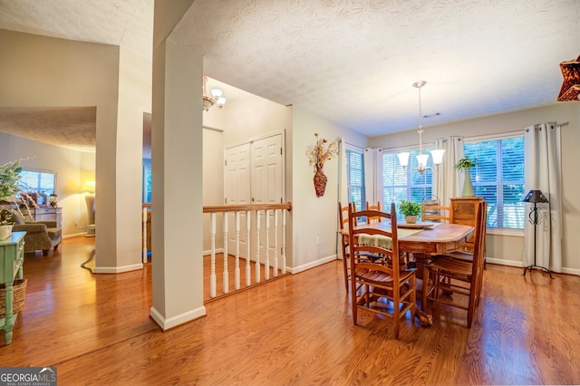 dining room featuring a textured ceiling, hardwood / wood-style floors, and a chandelier