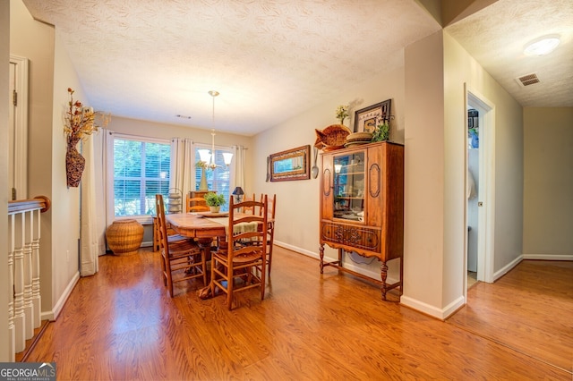 dining space featuring a textured ceiling and wood-type flooring