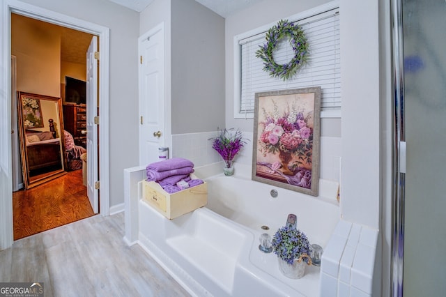 bathroom with a bath and wood-type flooring