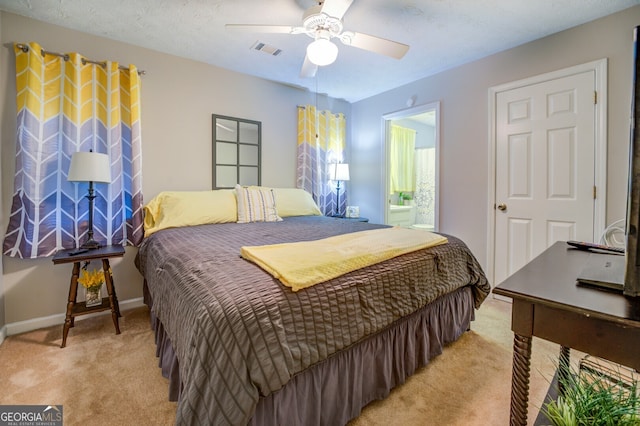 bedroom with a textured ceiling, ceiling fan, connected bathroom, and light colored carpet