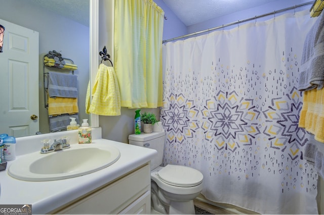 bathroom with toilet, a textured ceiling, and vanity