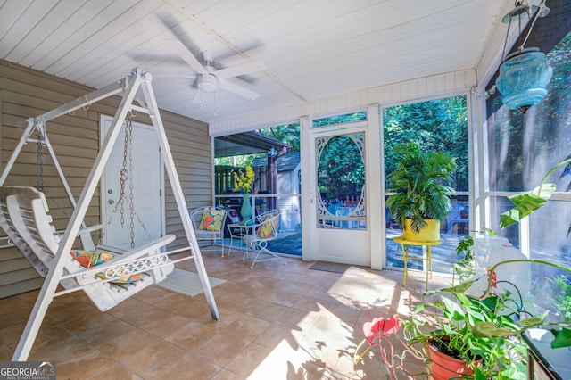 unfurnished sunroom featuring ceiling fan