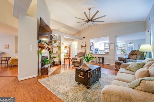 living room featuring ceiling fan, lofted ceiling, and wood-type flooring