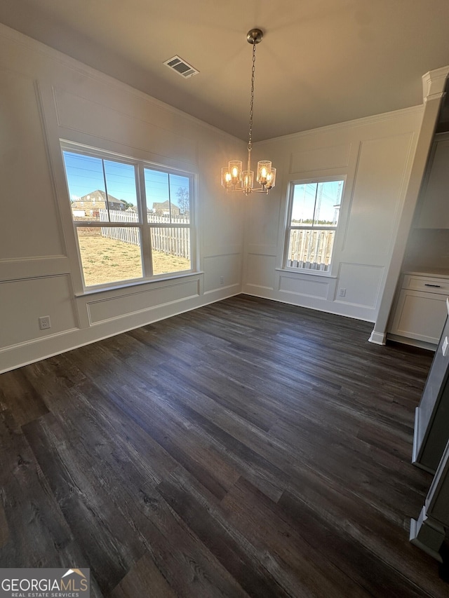 unfurnished dining area featuring a wealth of natural light, dark hardwood / wood-style floors, and a notable chandelier