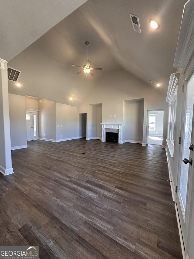 unfurnished living room with ceiling fan, dark hardwood / wood-style floors, lofted ceiling, and a fireplace