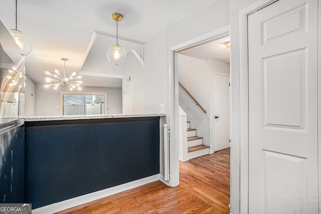 foyer entrance with wood-type flooring and a notable chandelier