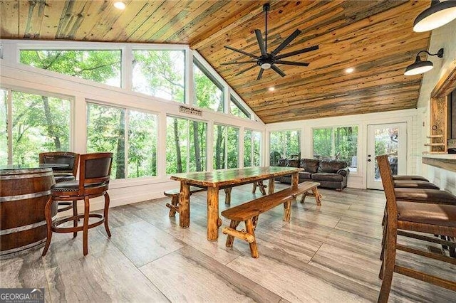 sunroom / solarium featuring wood ceiling, ceiling fan, lofted ceiling, and a healthy amount of sunlight