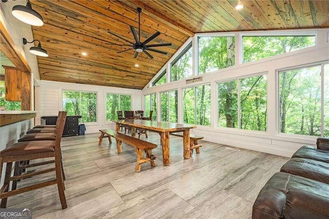 sunroom / solarium featuring wood ceiling, ceiling fan, lofted ceiling, and a wealth of natural light