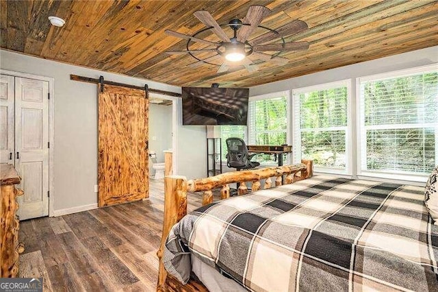 bedroom with dark hardwood / wood-style flooring, ensuite bath, ceiling fan, a barn door, and wood ceiling