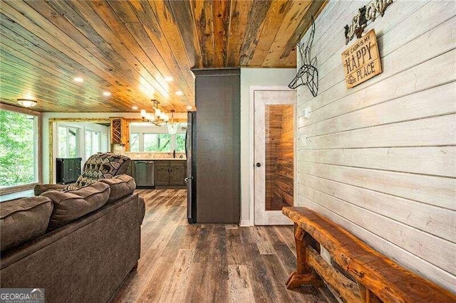 interior space featuring wood ceiling, an inviting chandelier, wood walls, and wood-type flooring