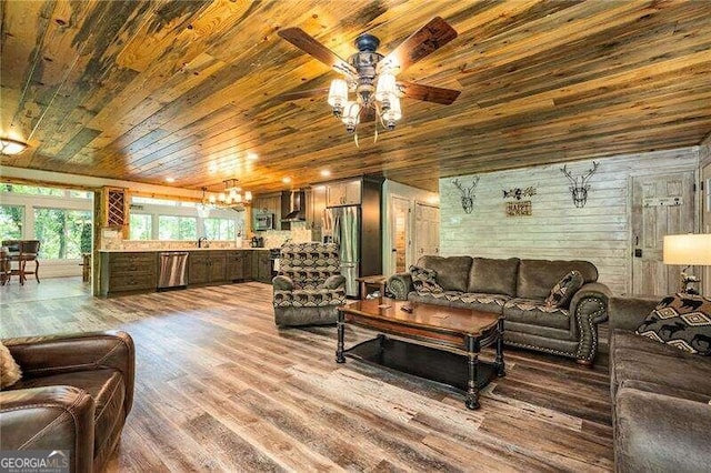 living room with wood walls, hardwood / wood-style floors, sink, ceiling fan, and wooden ceiling