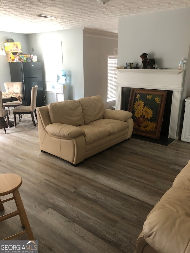 living room featuring a textured ceiling, dark hardwood / wood-style floors, and a wealth of natural light