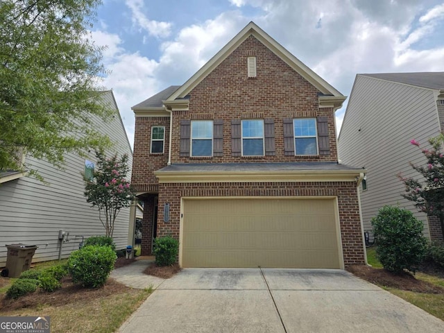 traditional-style home featuring driveway, an attached garage, and brick siding