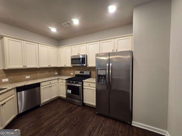 kitchen with light stone counters, dark wood-style flooring, stainless steel appliances, recessed lighting, and tasteful backsplash