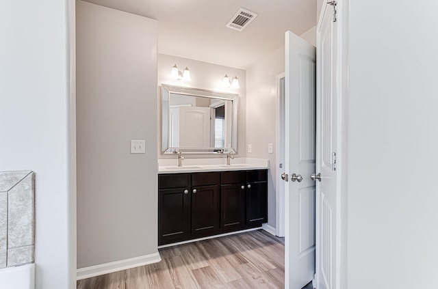 bathroom featuring dual vanity and hardwood / wood-style flooring