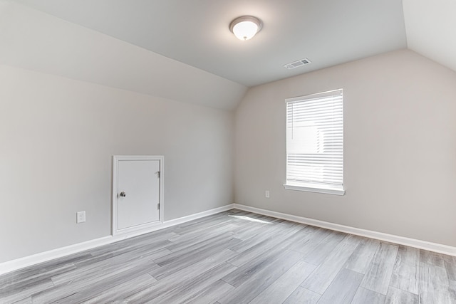 additional living space featuring lofted ceiling and hardwood / wood-style floors