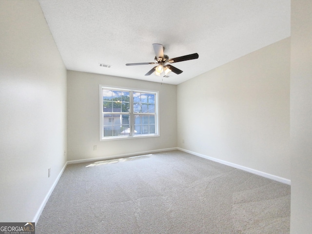 spare room with carpet, visible vents, ceiling fan, a textured ceiling, and baseboards