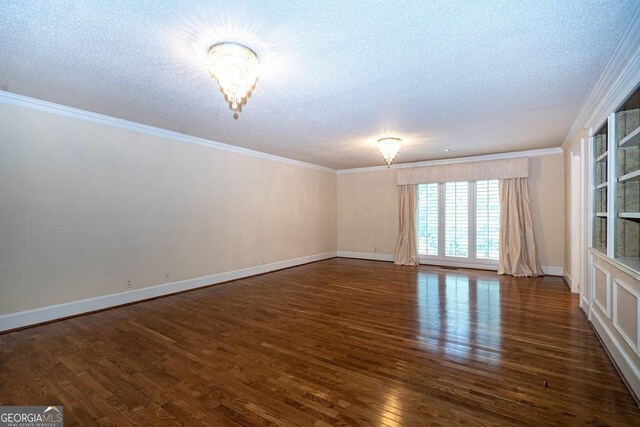 spare room featuring ornamental molding, a textured ceiling, and dark hardwood / wood-style flooring