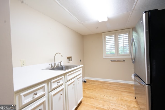 kitchen with stainless steel refrigerator, light hardwood / wood-style floors, white cabinetry, and sink