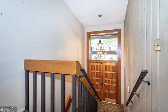 staircase featuring an inviting chandelier