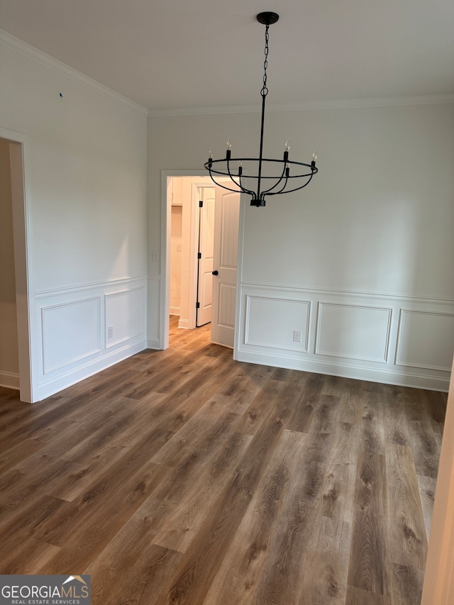 unfurnished dining area with ornamental molding, a chandelier, and dark hardwood / wood-style flooring