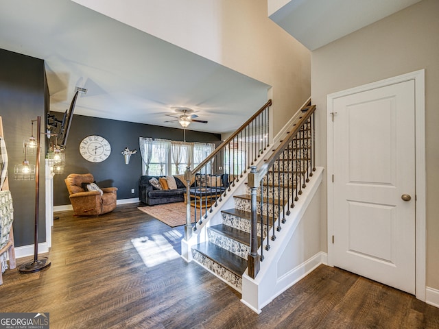 stairway featuring ceiling fan, baseboards, and wood finished floors