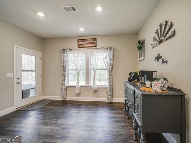 interior space with dark wood-style floors, baseboards, visible vents, and a healthy amount of sunlight