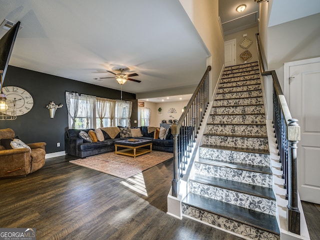 staircase with ceiling fan, baseboards, and wood finished floors