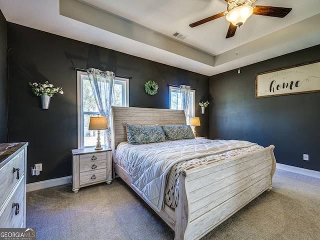 bedroom with baseboards, visible vents, a raised ceiling, and carpet flooring