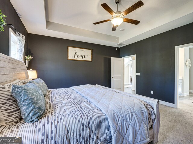 bedroom featuring carpet floors, visible vents, baseboards, and a raised ceiling