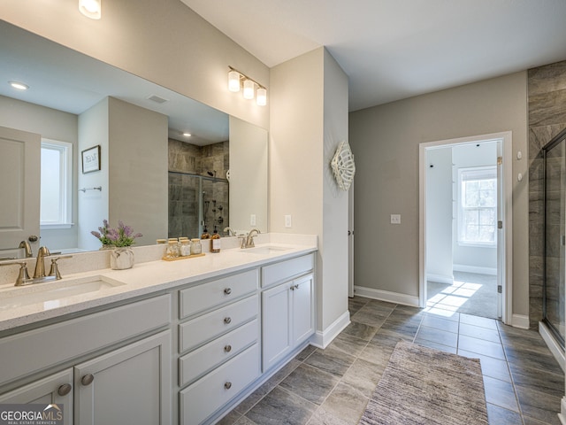 bathroom with a sink, a shower stall, and double vanity