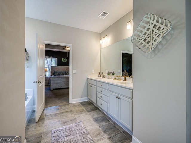 ensuite bathroom featuring double vanity, visible vents, a sink, ensuite bath, and baseboards