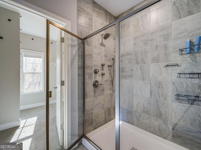 bathroom with a shower stall and baseboards