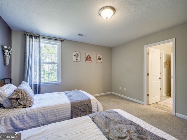 carpeted bedroom featuring a textured ceiling, visible vents, and baseboards