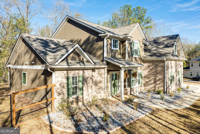 view of front of home featuring brick siding and fence