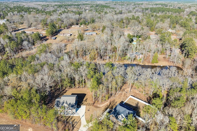 drone / aerial view with a water view and a forest view