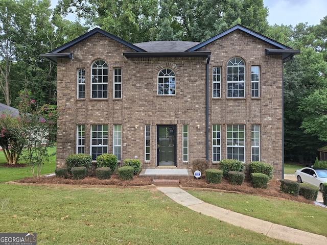 colonial inspired home featuring a front lawn