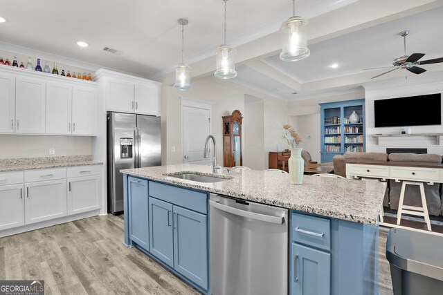 kitchen with sink, appliances with stainless steel finishes, light hardwood / wood-style floors, ceiling fan, and white cabinets