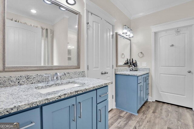 bathroom featuring crown molding, dual vanity, and hardwood / wood-style flooring