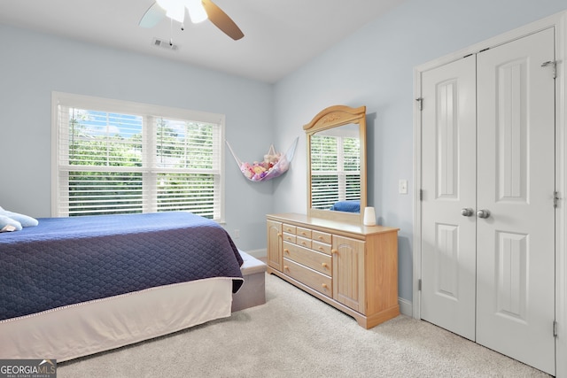 bedroom featuring ceiling fan, light colored carpet, and a closet