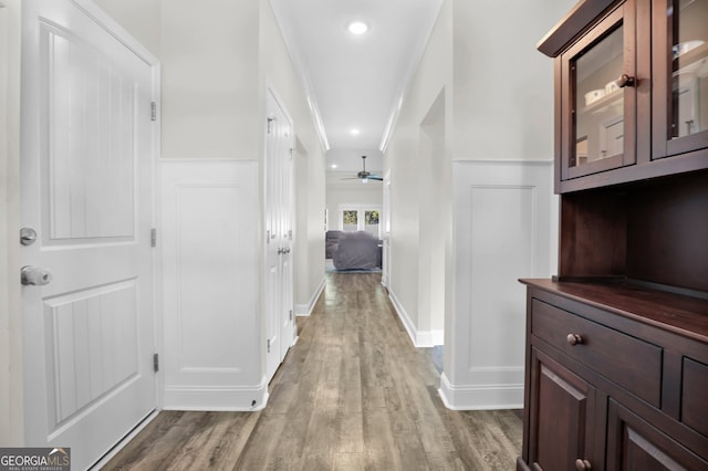 hall featuring wood-type flooring and ornamental molding