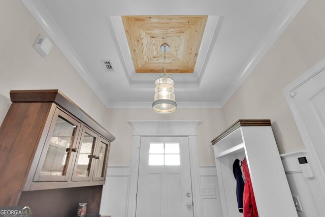 interior space with a tray ceiling and crown molding